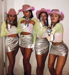 four women in silver skirts and pink hats