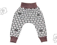 a pair of baby pants with black and white designs on the bottom, and brown trim