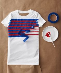 a t - shirt with red, white and blue strips on it next to scissors