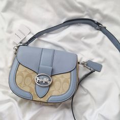 New Coach Georgie Saddle Bag In Signature Canvas C2806 Light Khaki/Marble Blue $350 Signature Coated Canvas, Smooth Leather And Refined Pebble Leather Inside Multifunction Pockets Snap Closure, Fabric Lining Outside Open Pocket Detachable Strap With 20 3/4" Drop For Shoulder Or Crossbody Wear 8 1/4" (L) X 6 3/4" (H) X 2 3/4" (W) Blue Luxury Leather Saddle Bag, Luxury Blue Leather Saddle Bag, Designer Light Blue Bag With Detachable Strap, Designer Light Blue Bags With Detachable Strap, Blue Coated Canvas Satchel Bag, Blue Coated Canvas Satchel, Elegant Blue Saddle Bag For Everyday Use, Blue Coated Canvas Shoulder Bag For On-the-go, Blue Coated Canvas Top Handle Shoulder Bag