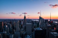 the sun is setting over new york's skyline as seen from top of the rock