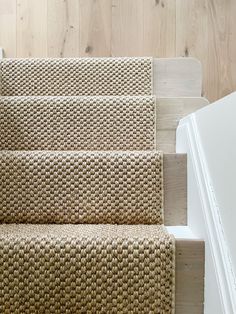 a carpeted stair case next to a white door