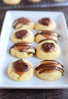 cookies with chocolate drizzled on them sitting on a white plate