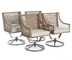 three wicker chairs sitting on top of metal bases