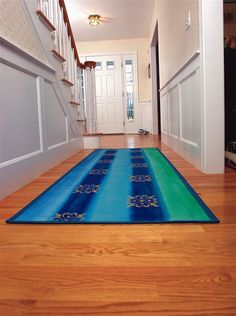 a blue and green rug is on the floor in front of a white door with stairs