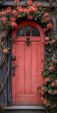 an orange door with pink flowers on it and vines growing over the front entrance,