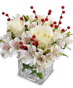 a vase filled with white flowers and red berries