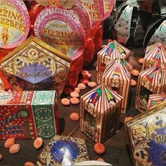 there are many colorful boxes and plates on the table with candy candies in them