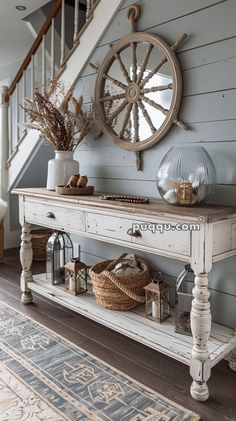 a white table sitting under a stair case next to a wooden handrail with an old wheel on it