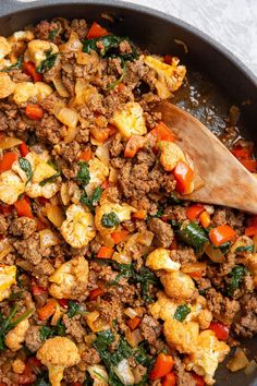 a skillet filled with meat and vegetables