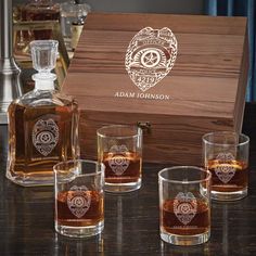 an assortment of whiskey glasses sitting next to a wooden box