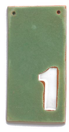 a green and white ceramic number one sign