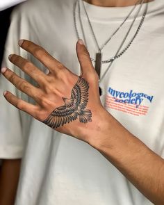 a person with a bird tattoo on their hand