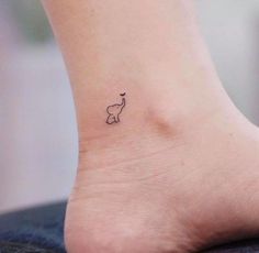 an elephant tattoo on the foot of a woman's left ankle is shown in black ink