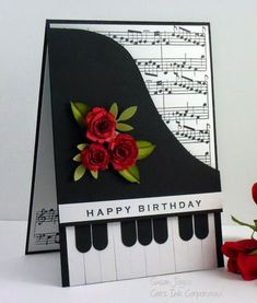 a birthday card with roses on top of a piano