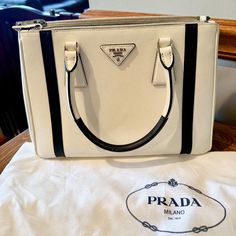 Prada Saffiano Lux Double Zip Color: White & Black Measures: 11.25l X 5w X 7.75d Condition: Bought Directly From Prada, Lightly Used, Very Clean, Some Scuffing On The Bottom Four Corners. Comes With Dust Bag, Guarantee Card, Shoulder Strap, Paperwork From Prada. Elegant White Saffiano Leather Bag, White Saffiano Leather Evening Bag, White Saffiano Leather Office Bag, Evening White Saffiano Leather Bag, Prada Saffiano, Prada Bag, Dust Bag, Prada, White And Black