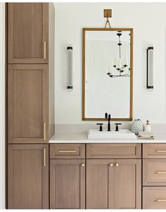 a bathroom with two sinks, cabinets and a large mirror on the wall above it