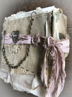 an old piece of cloth with chains attached to it and some charms hanging off the side