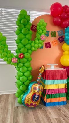 a room decorated with balloons, streamers and decorations for a mexican themed birthday party