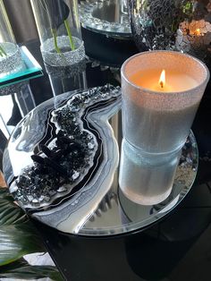 a candle is sitting on a glass plate