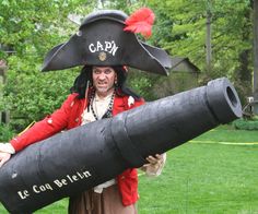 a man dressed as a pirate holding a giant cannon