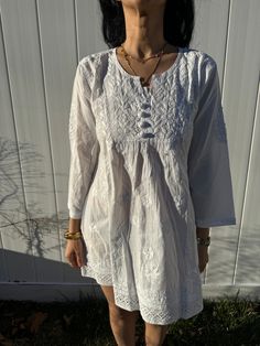 Crafted from crisp, lightweight pure cotton. Featuring our Salt white slip on A-line bohemian short dress. Whether its a day party, lounging at home, beach day, an intimate summer soiree or a celebration that lasts all night, our dress is all you need to exude elegance without compromising on comfort. Also bump friendly. Fit: Relaxed Fit / Available in S/M/L/XL/XXL Sizes (XS is sold out currently but are on back order for April).  Care: Hand wash/delicate machine wash cycle with cold water only. Hot water & dryer to be strictly avoided.  Hand embroidery is done in neckline & on full dress with traditional paisley, and floral motif full sleeves for an elegant look. Ethically crafted in India, our pieces feature beautiful and intricate 'chikankari' work. This highly skilled and elaborate emb White Cotton Tunic With Floral Embroidery, White Cotton Tunic With Relaxed Fit, White Chikankari Embroidery Summer Tunic, White Summer Folk Style Tunic, White Summer Folk Tunic, White Folk Tunic For Summer, White Folk Style Summer Tunic, White Casual Tunic With Floral Embroidery, Summer Cotton Tunic With Chikankari Embroidery