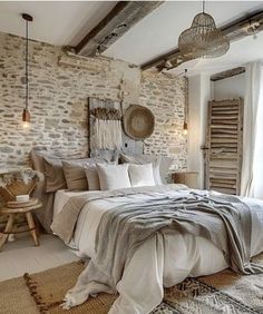 a bedroom with stone walls and white bedding, rugs on the floor and wooden furniture