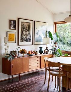 a dining room filled with furniture and pictures on the wall