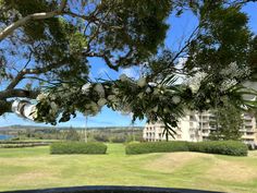 the view from behind some trees in front of an apartment building and golf course on a sunny day