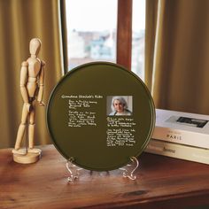 a wooden mannequin next to a plaque on a table