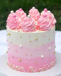 there is a pink and white cake with sprinkles on the top it