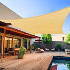 an outdoor deck with a table and chairs next to a swimming pool