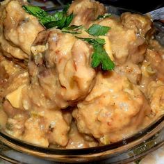 a glass bowl filled with meat covered in gravy