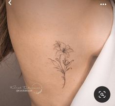 a woman's back with a flower tattoo on her left side ribcage