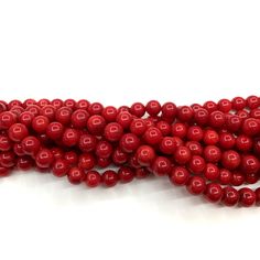 red beads are lined up on a white surface