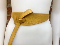 "NEW STYLE. Mustard yellow OBI BELT in genuine leather. Waist belt in soft natural leather. Mustard color belt. Yellow 80s style belt. One side \"passes through\" the other through the 2 eyelets and then can be either hidden behind or passed through again at the front, please see pictures! Available in mustard yellow, black and taupe color ( light brown-dark greyish beige) The belt is 116 cm (46 in) long 6 cm (2 1/2in) wide at one side and 2 cm ( 3/4 in) at the other side Our genuine leather and Leather Wrap Belt, Wide Belts For Women, Leather Waist Belt, Yellow Belt, Obi Belt, Wrap Belt, 80s Style, Mustard Color, Yellow Mustard