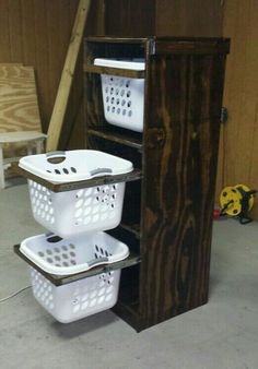 three white baskets stacked on top of each other in front of a wooden structure with ladders