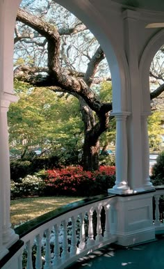 an outdoor gazebo with trees and flowers in the background