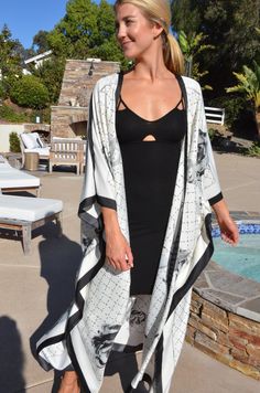 Enjoy summer in this beautiful silk white and black kimono. Dressy or casual . Not a sheer fabric. Medium weight silk. One size. The width is 52 inches when closed. The length is 50 inches. Elegant V-neck Kimono For Beach Cover-up, Elegant Long Vacation Cover-up, Chic White Kimono For Beach Cover-up, White V-neck Kimono For Daywear, White V-neck Kimono For Day Out, Elegant V-neck Kimono For Vacation, Chic Kimono For Vacation, Chic Open Front Kimono For Vacation, Elegant Summer Daywear Kimono