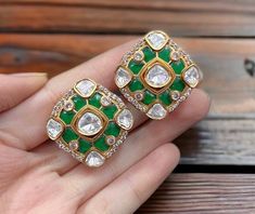 Polki Kundan Stud Earrings, inspired by Sabyasachi, feature a blend of emerald and ruby Kundan designs. Adorned with moissanite Polki diamonds and set in gold, these designer statement pieces showcase exquisite Indian craftsmanship. Perfect as a luxurious gift, they add timeless elegance to any jewelry collection. *𝐏𝐑𝐎𝐃𝐔𝐂𝐓 𝐃𝐄𝐓𝐀𝐈𝐋* * Material: Brass * Plating: Gold Plated * Stone: Semi Precious Kundan & Polki *𝐃𝐈𝐌𝐄𝐍𝐒𝐈𝐎𝐍𝐒* * Earrings- Weight: 10 gm Each, Length: 1.1 Inches, Green Earrings For Anniversary And Festivals, Designer Green Earrings For Gift, Designer Green Jewelry For Anniversary, Green Earrings For Formal Diwali Occasion, Green Formal Earrings For Diwali, Polki Studs, Sabyasachi Jewellery, Polki Earrings, Earrings Emerald