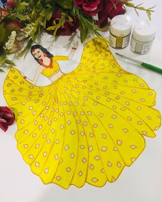 a paper doll is sitting on a table with flowers and glues around it,