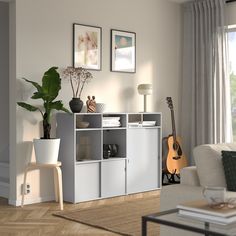 a living room filled with furniture and a guitar on top of a book shelf next to a window