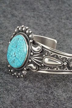 This stunning Kingman turquoise and sterling silver bracelet was made by Navajo silversmith Derrick Gordon. The back is signed Derrick and stamped Sterling.Size: 5 3/8" (will fit up to a 6 1/2" wrist)Gap: 1 1/8"Width: 1 1/2"Cuff Width: 1/2"Free shipping on all orders! We ship with USPS and always include tracking. All orders ship within a day of payment.Returns are accepted up to 30 days after you receive your order. Just send us a message. Our shop offers cash back or store credit. The item mus Western Style Blue Sterling Silver Bracelet Gift, Southwestern Style Etched Turquoise Jewelry, Southwestern Etched Turquoise Jewelry, Southwestern Turquoise Etched Jewelry, Handmade Turquoise Sterling Silver Western Bracelet, Western Style Engraved Blue Jewelry, Southwestern Style Sterling Silver Turquoise Bracelet, Southwestern Stamped Turquoise Sterling Silver Bracelet, Southwestern Turquoise Stamped Sterling Silver Bracelet