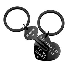 two black heart shaped key chains with the words you hold the key to my heart