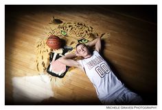 a woman laying on top of a wooden floor next to a tiger head with green eyes