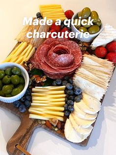 a platter with cheese, olives, meat and fruit on it that says made a quick charcuterie