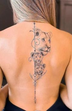 the back of a woman's neck with a lion and arrow tattoo on it