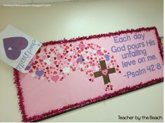 a bulletin board decorated with hearts and a cross for valentine's day on the wall