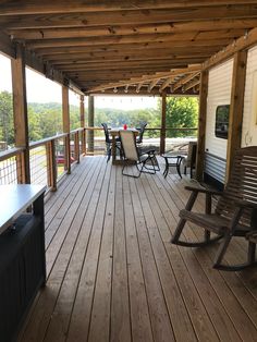 a covered porch with chairs and tables on it