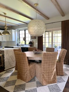 a dining room table with chairs and a chandelier hanging from it's ceiling